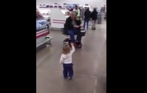 Cute toddler waves hi and hugs strangers in grocery store